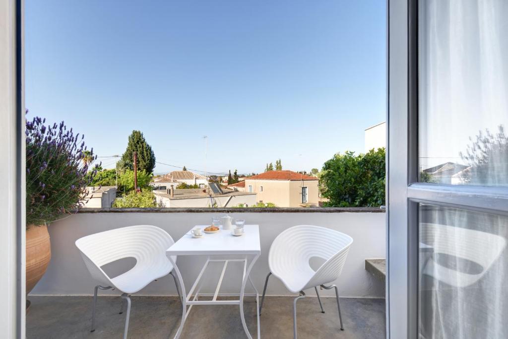 a white table and white chairs on a balcony at Orloff Resort in Spetses