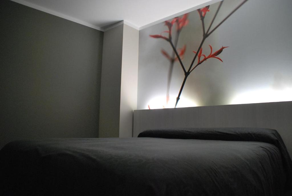 a bedroom with a bed with a vase on the wall at Aparthotel Meseguer in Alcañiz