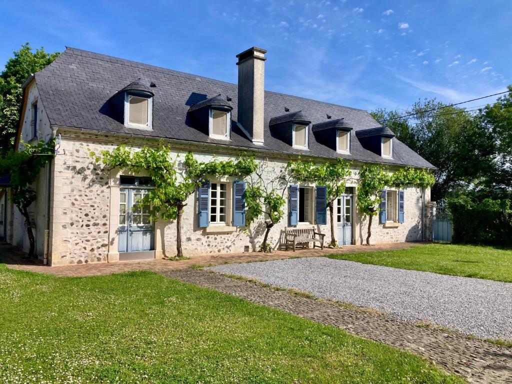 a brick house with windows and a roof at Cottage authentique et chaleureux entre Pau et Lourdes pour 7 personnes in Nousty