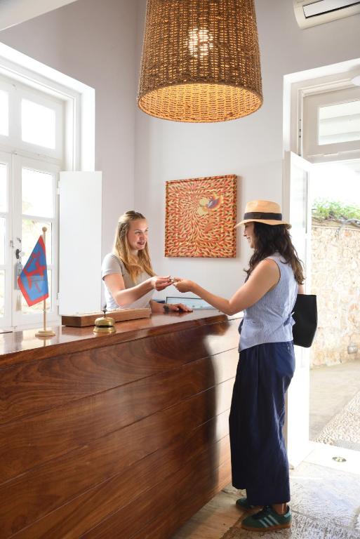 two women are standing at a counter in a room at Orloff Resort in Spetses