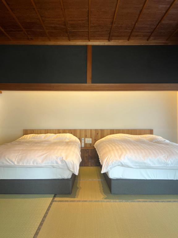 Postel nebo postele na pokoji v ubytování 古民家ラグジュアリーホテル 金井西洋館