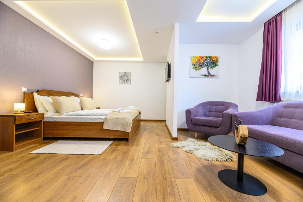 Un dormitorio con una cama, un sofá y una mesa. en SunShine Villa Brasov, en Brasov