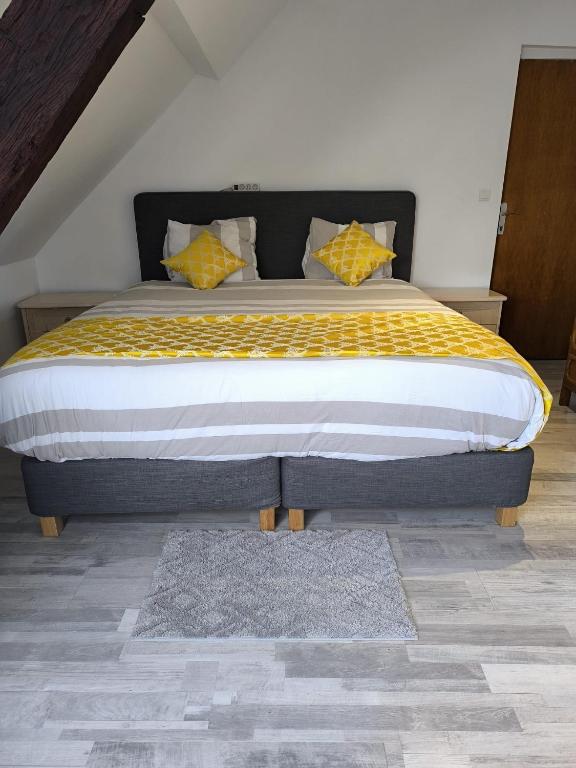 ein Schlafzimmer mit einem großen Bett mit einer gelben Decke in der Unterkunft Engy2 in Lens