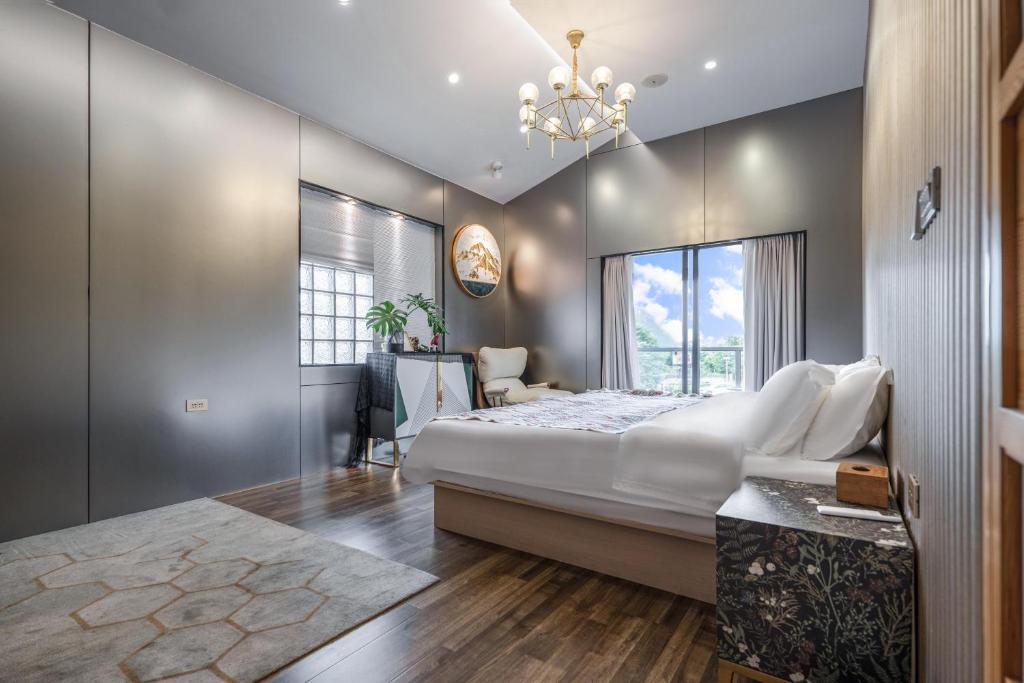 um quarto com uma cama grande e um lustre em Guilin Tranquil Peaks Retreat by Reed Flute Cave em Guilin
