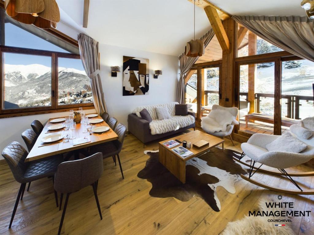 un salon avec une table, des chaises et un canapé dans l'établissement Résidence Ariondaz Anemone - Penthouse familial skis aux pieds MAE-4724, à Courchevel