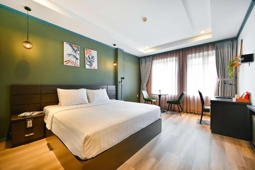 a bedroom with a bed and a table and chairs at THE STAR HOTEL - Phú Mỹ Hưng, Hồ Chí Minh in Ho Chi Minh City