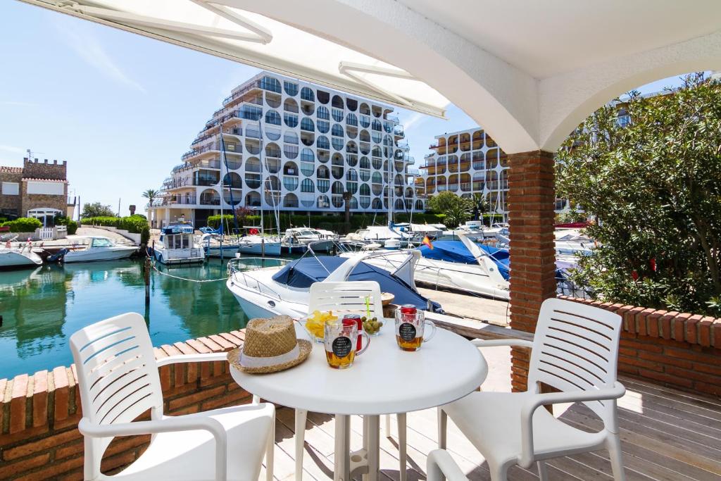 a white table and chairs on a balcony with a marina at Vista Roses Mar - Casa Pescador in Empuriabrava