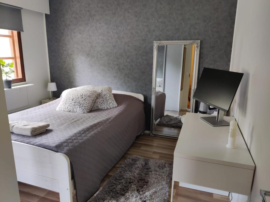 a bedroom with a bed and a mirror and a desk at Two-room apartment with sauna in the Old Town in Savonlinna