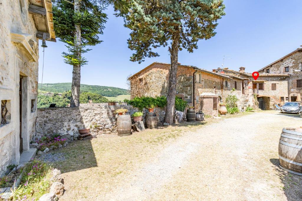 a village street with stone buildings and trees at Romantic Apartment In Chianti Classico - Happy Rentals in Castelnuovo Berardenga