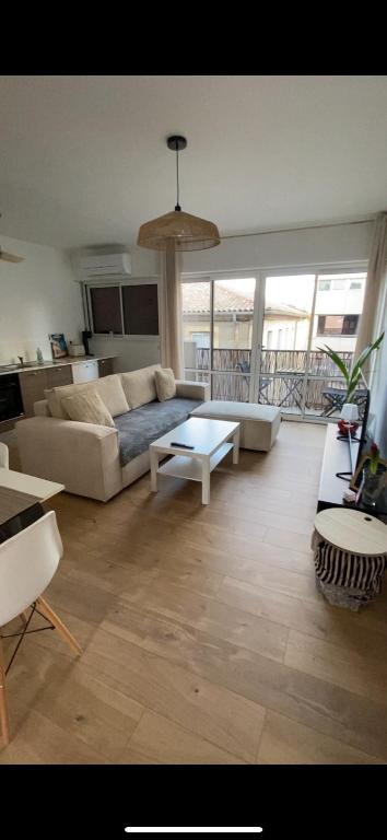 un salon avec un canapé et une table dans l'établissement Au cœur de Nîmes, un appart lumineux où il fait bon vivre, à Nîmes