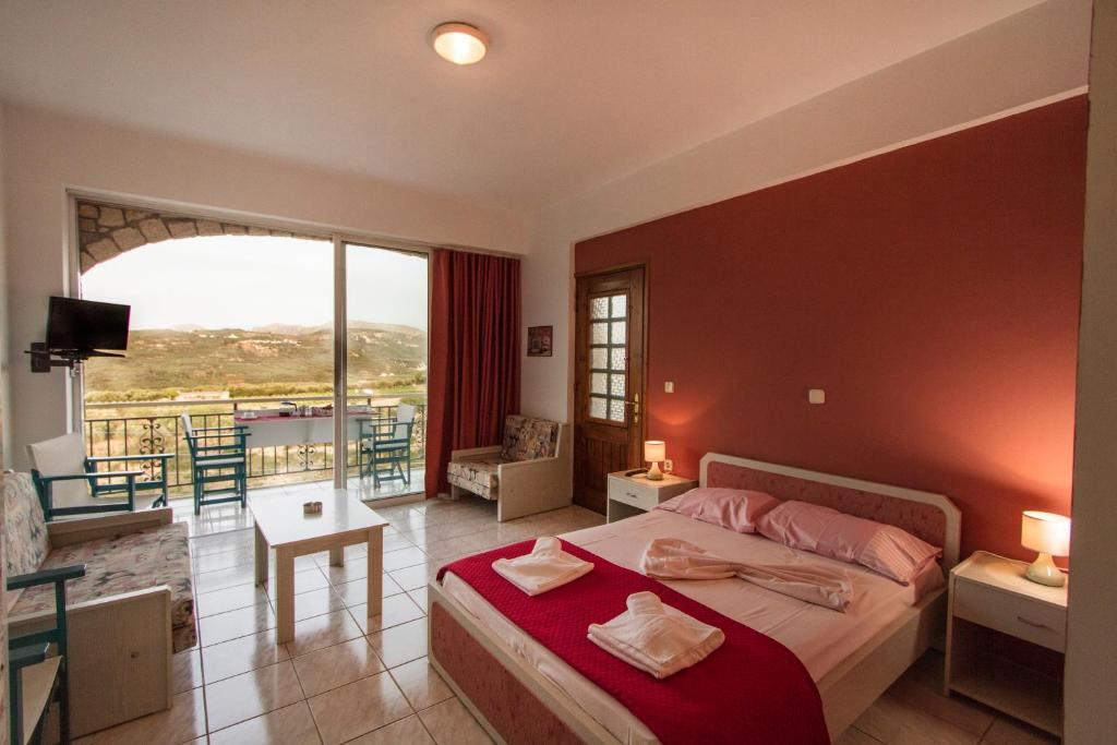 a bedroom with a bed and a room with a balcony at Kallergiana Studios in Kissamos