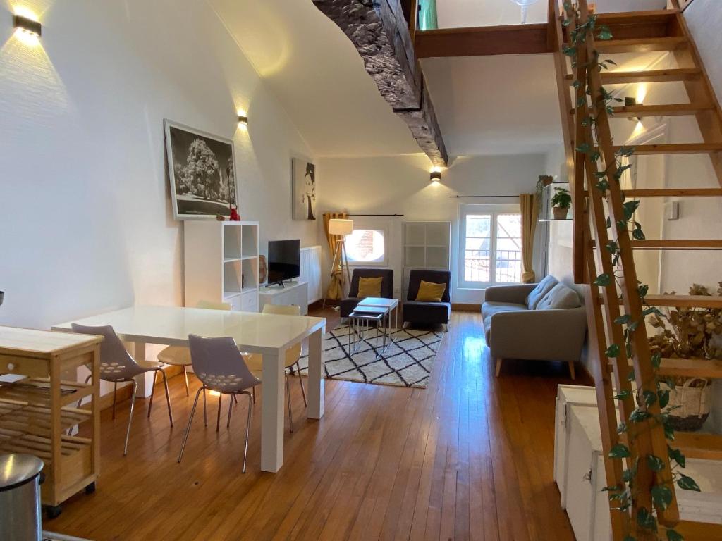 un salon avec une table et des chaises et un salon dans l'établissement L'Empeyral - Hypercentre - Mezzanine, à Albi