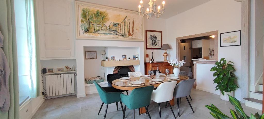 a dining room with a table and chairs and a fireplace at Le Petit Clos - Village house in Saint-Geniès in Saint-Geniès