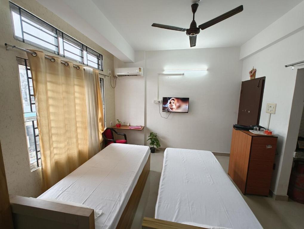 Camera ospedaliera con 2 letti e un ventilatore a soffitto di The Samay Inn ,Jalukbari a Guwahati