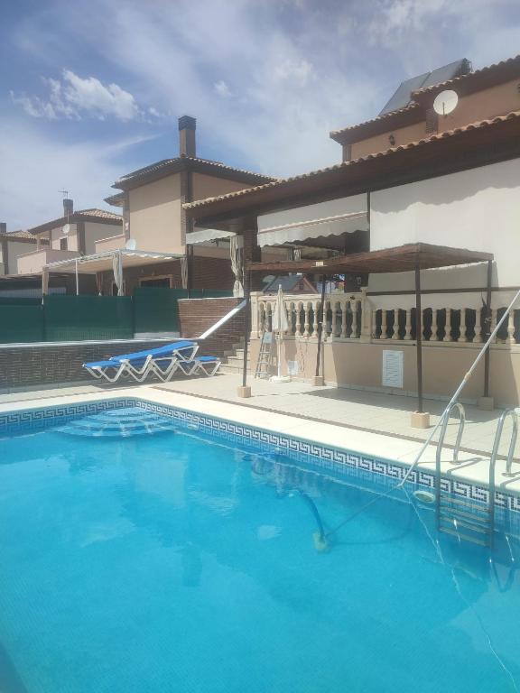 a swimming pool in front of a house at El Chalét de Manolo in Aljaraque