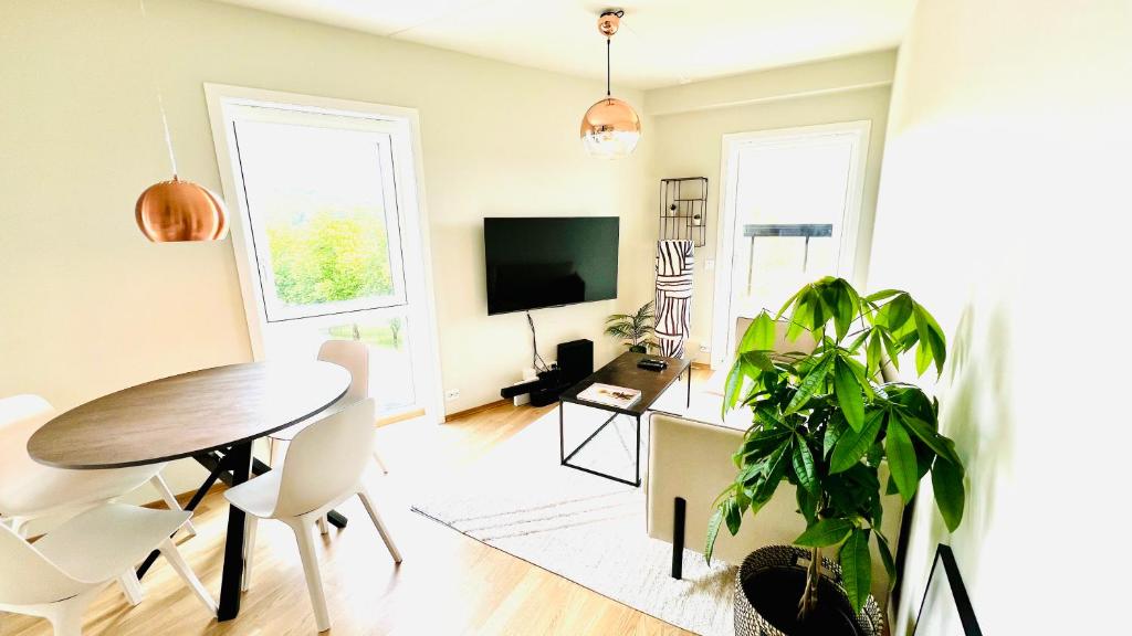un salon avec une table et une télévision dans l'établissement Penthouse Apartment, à Kristiansand
