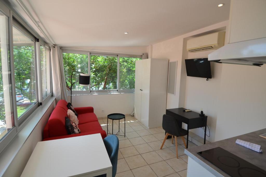 un salon avec un canapé rouge et une table dans l'établissement STUDIO CASSIN - next to tramway line 2 near airport, à Nice