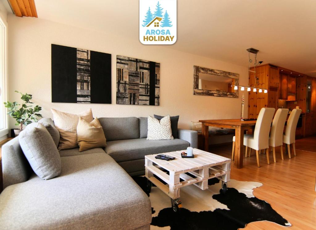 una sala de estar con un sofá y una mesa en Rothornblick 28 by Arosa Holiday, en Arosa
