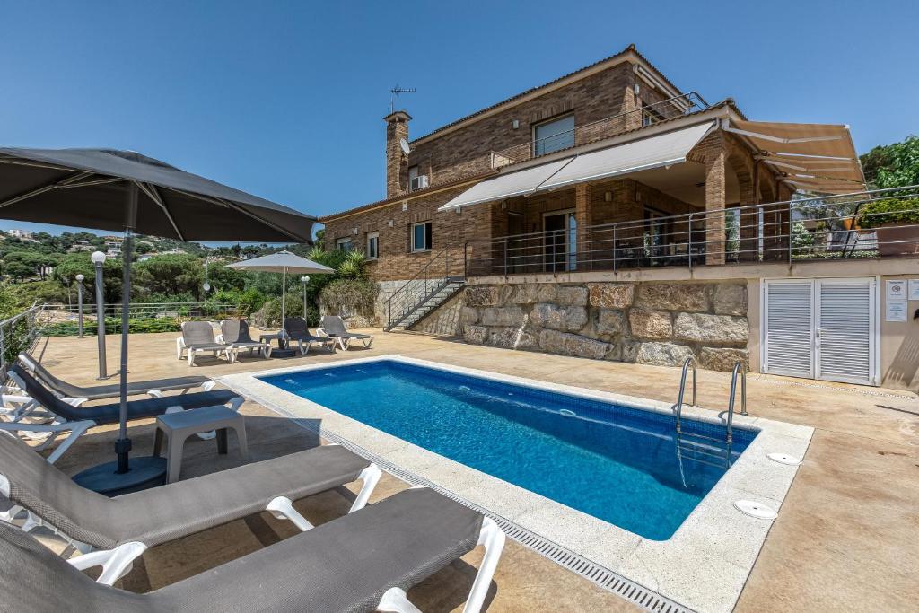 eine Villa mit Swimmingpool und ein Haus in der Unterkunft Olive in Lloret de Mar