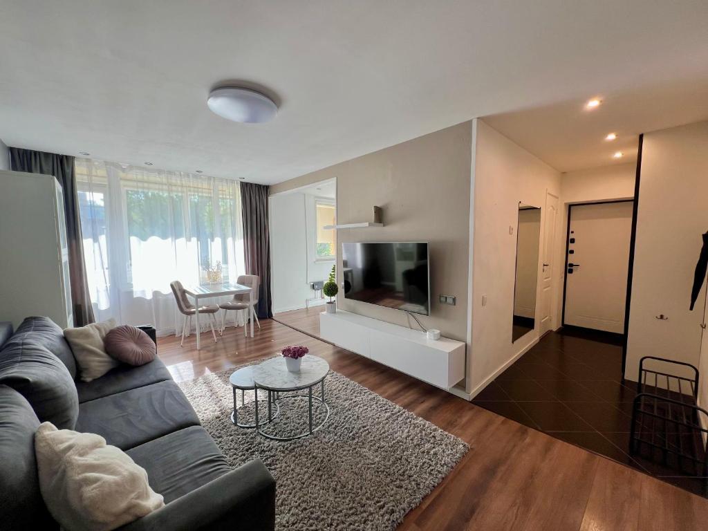 a living room with a couch and a tv at SORD apartment in Liepāja