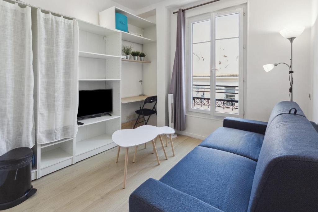 un salon avec un canapé bleu et une télévision dans l'établissement Le Citadin - Hypercentre - Cosy - Shopping - WIFI, à Nice