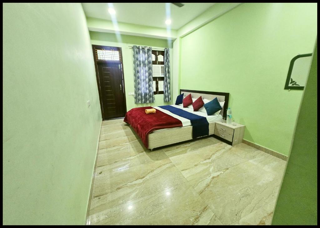 瓦拉纳西Hotel Devans Palace Stay Near Kashi Vishwanath Temple - Fully Air Conditioned rooms - Free wi-fi- & Parking - Best - Hotel的一间卧室配有一张带红色和蓝色毯子的床