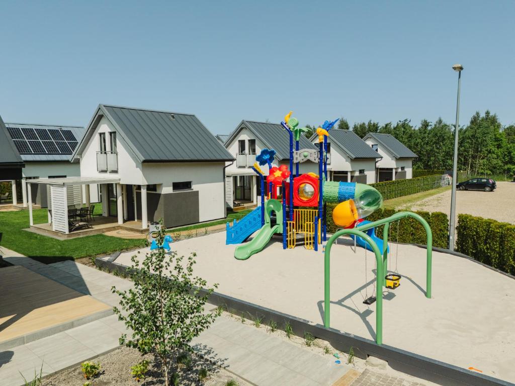 a playground in a yard with houses at Domki Morski Raj B in Dębki