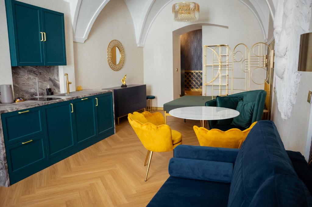 a kitchen with green cabinets and a table with yellow chairs at Luxury apartments Banská Bystrica on the main square- LUSSO, FRESCO, PURE in Banská Bystrica
