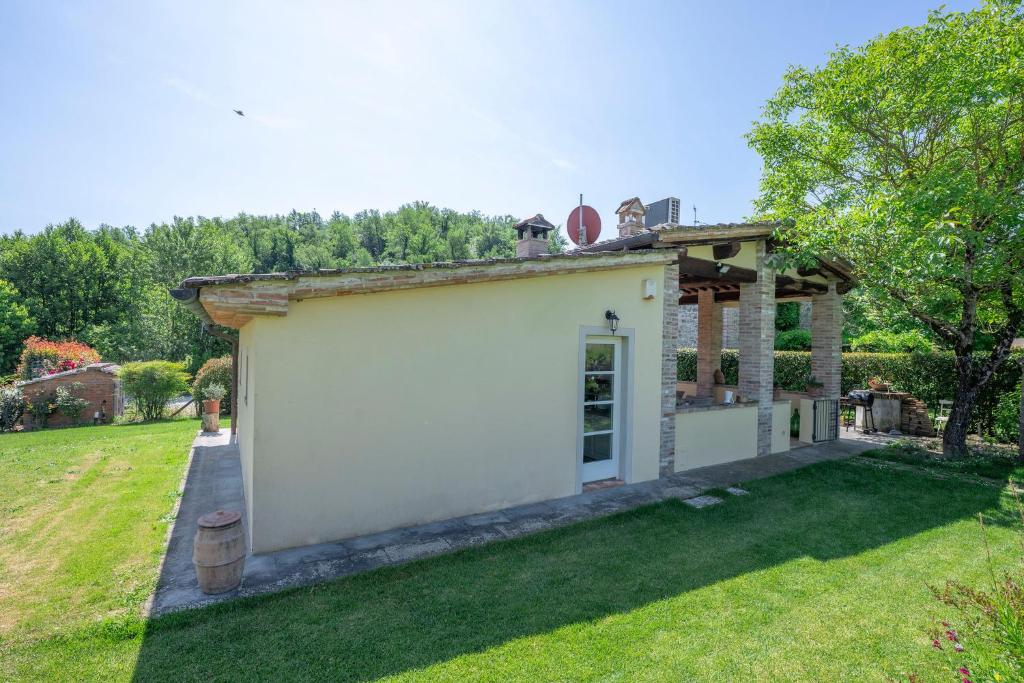 - un petit bâtiment blanc dans une cour dans l'établissement Il Fienile Toscano, à Montevarchi