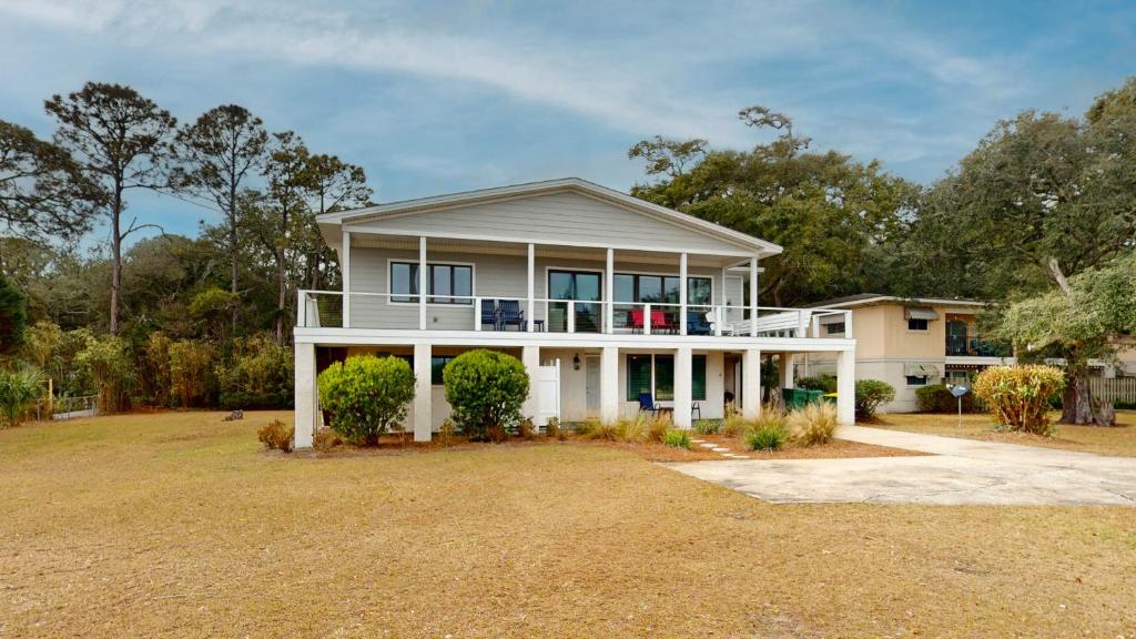 uma grande casa branca com um grande quintal em CLUBHOUSE COTTAGE home em Jekyll Island