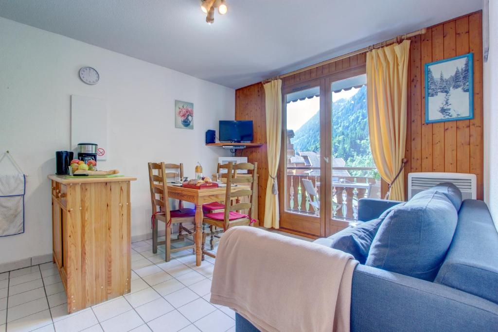 un salon avec un canapé bleu et une table dans l'établissement Ranfolly 10, à Morzine