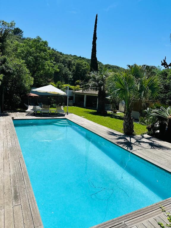 une grande piscine bleue dans une cour dans l'établissement Les Lodges de l'Etang, à Roquebrune-sur Argens