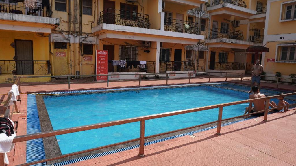 Una gran piscina azul frente a un edificio en Baga Apartments Goa, en Calangute