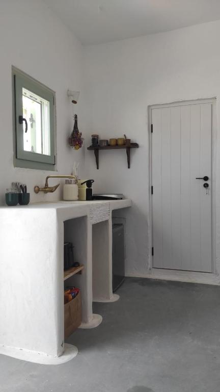 a kitchen with a white counter and a door at Salty Yard Holiday Home in Serifos Chora