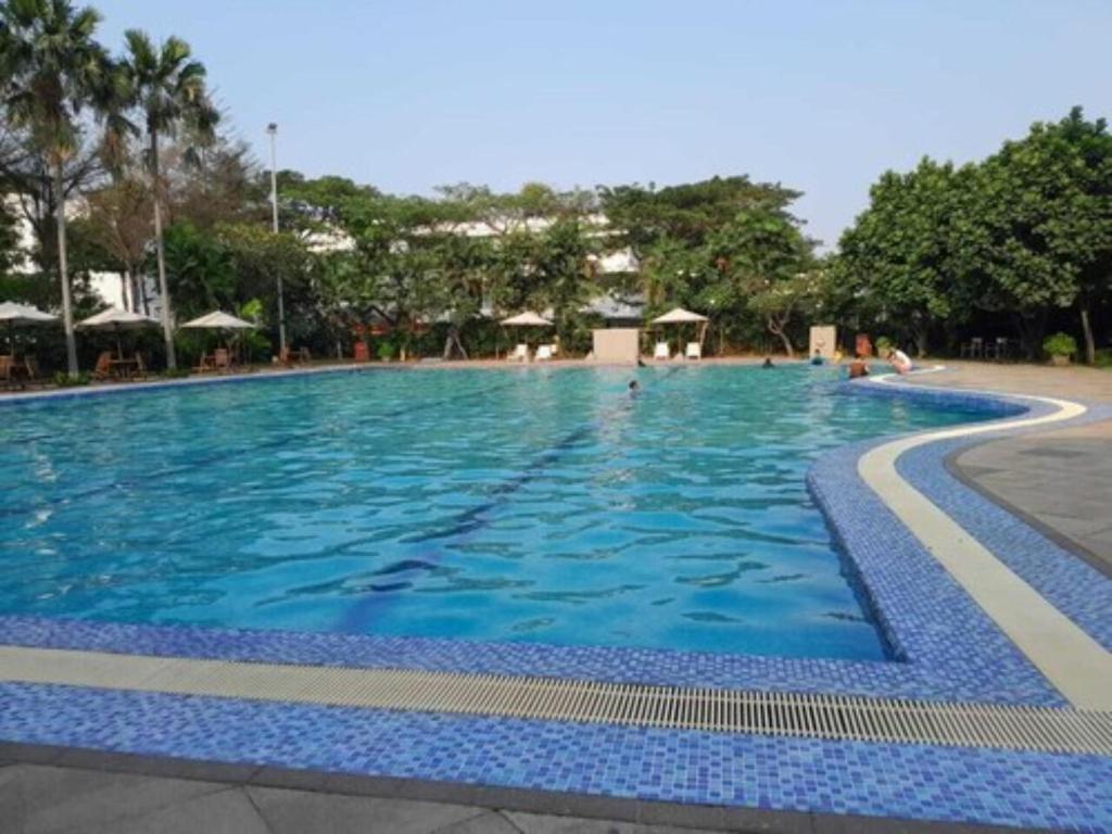 a large blue swimming pool with people in it at Smart Inn at Aeropolis Residence in Teko