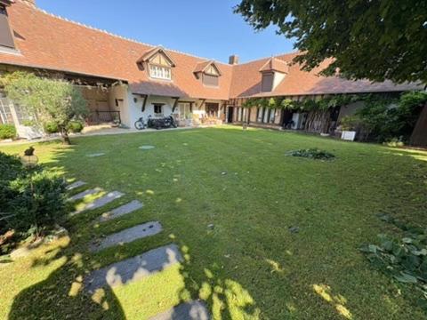 a large yard with a house with a grass yard sidx sidx sidx at La tanière des ours in Chaumont-sur-Tharonne
