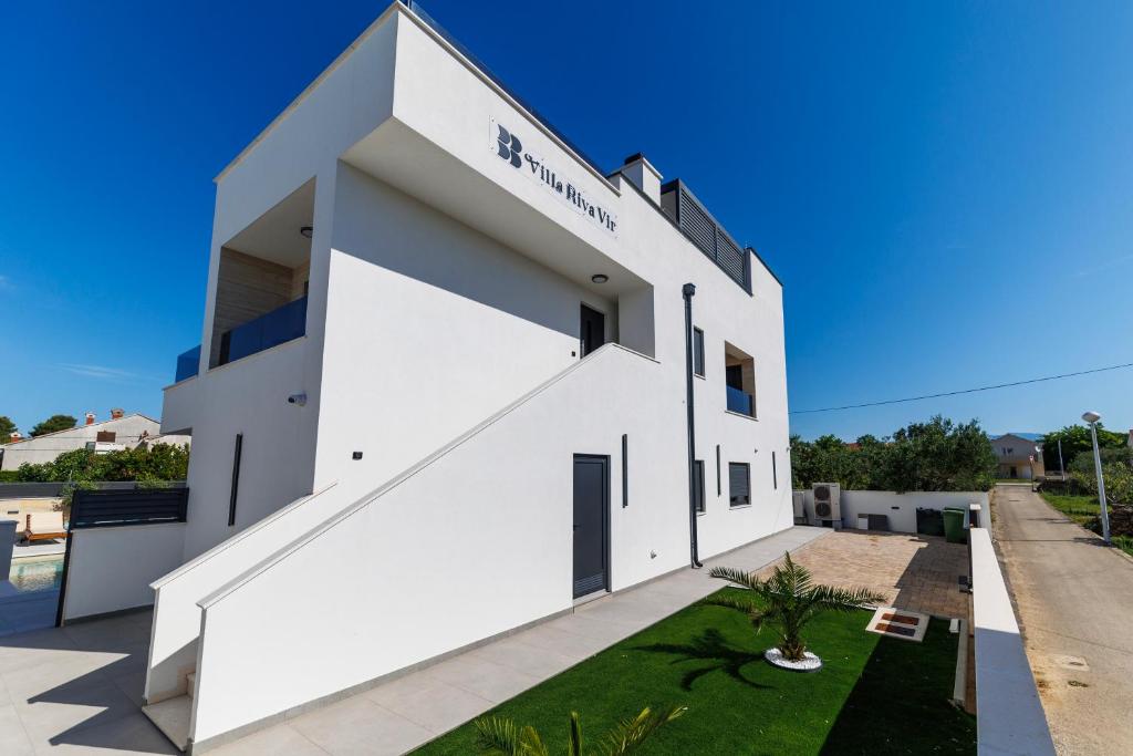 a white building with a sign on it at Villa Riva Vir Apartment in Vir