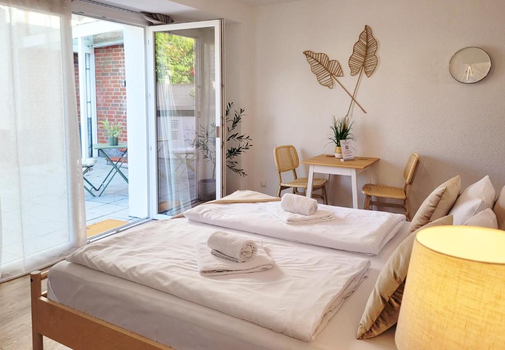 a bedroom with a bed and a sliding glass door at Moderner Ankerplatz mit Terrasse direkt am Hafen "Momentic" in Neustadt in Holstein