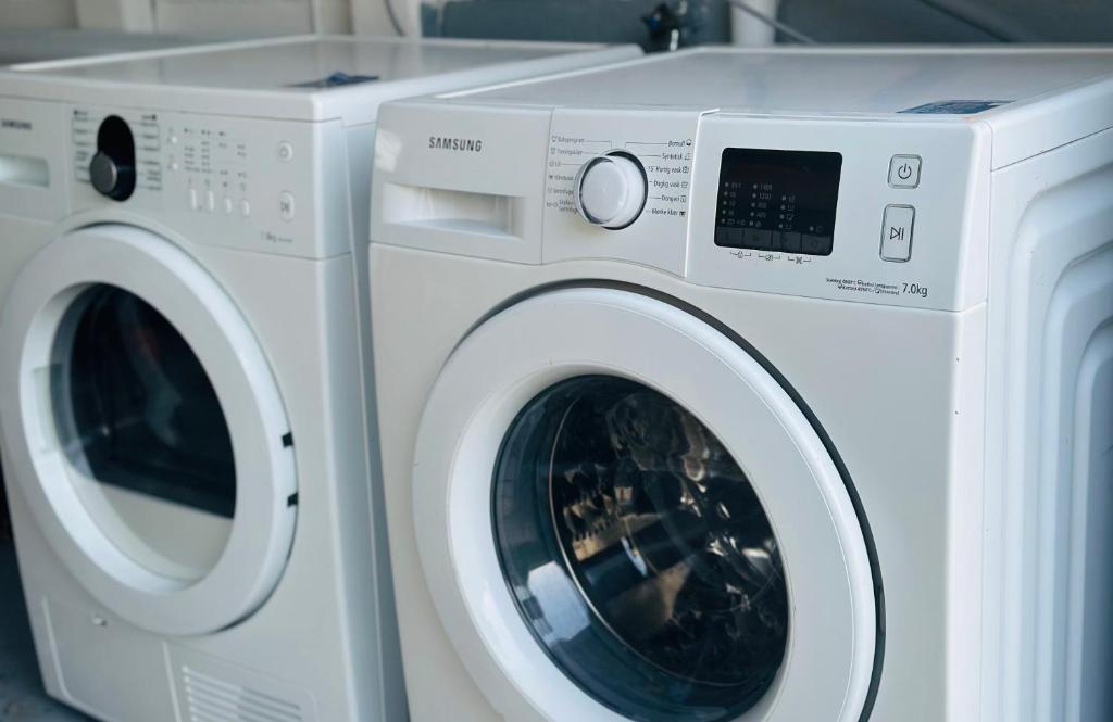 a white washer and dryer sitting next to each other at New Vy Gärsnäs 2 in Gärsnäs