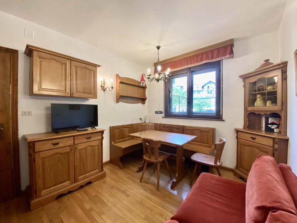 Cozy flat in amazing central location في كورتينا دامبيتزو: غرفة معيشة مع طاولة وغرفة طعام