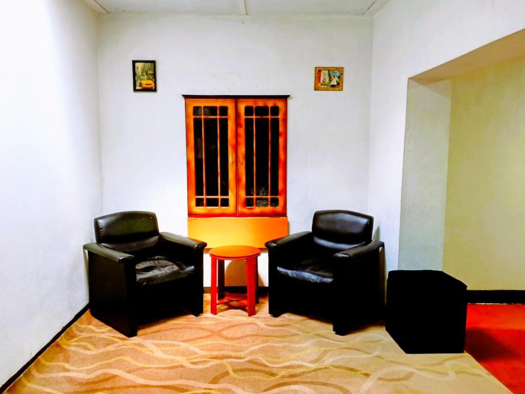 ANN FIELD BUNGALOW Home Stay في نوارا إليا: كرسيين وطاولة في غرفة المعيشة