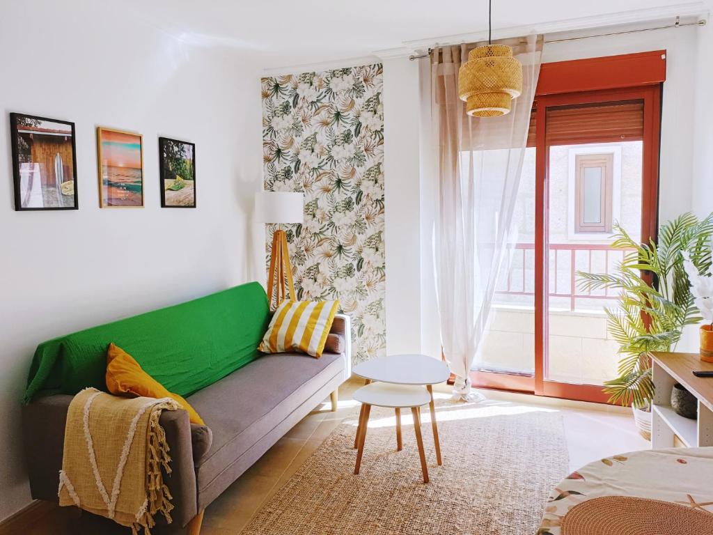 a living room with a green couch and a table at Ondas do Mar Boutique Stays - Portonovo 5 in Portonovo