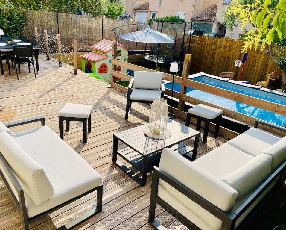 un patio avec une table et des chaises et une piscine dans l'établissement Maison familiale avec jardin et piscine, à Roquebrune-sur Argens