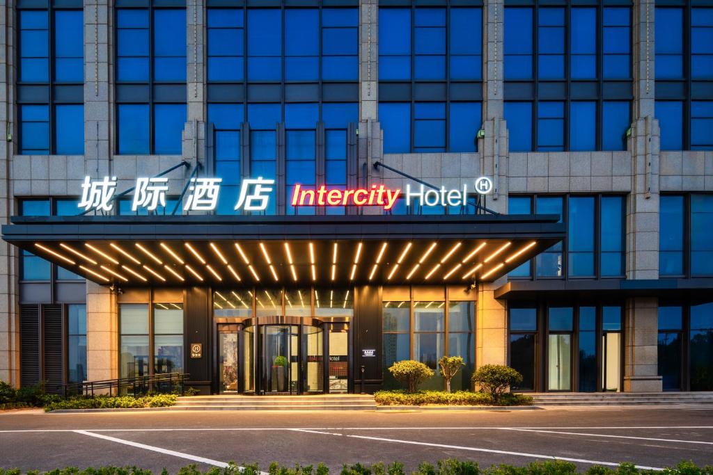 Un edificio de oficinas con un cartel de hotel de emergencia. en IntercityHotel Rizhao Downtown, en Rizhao
