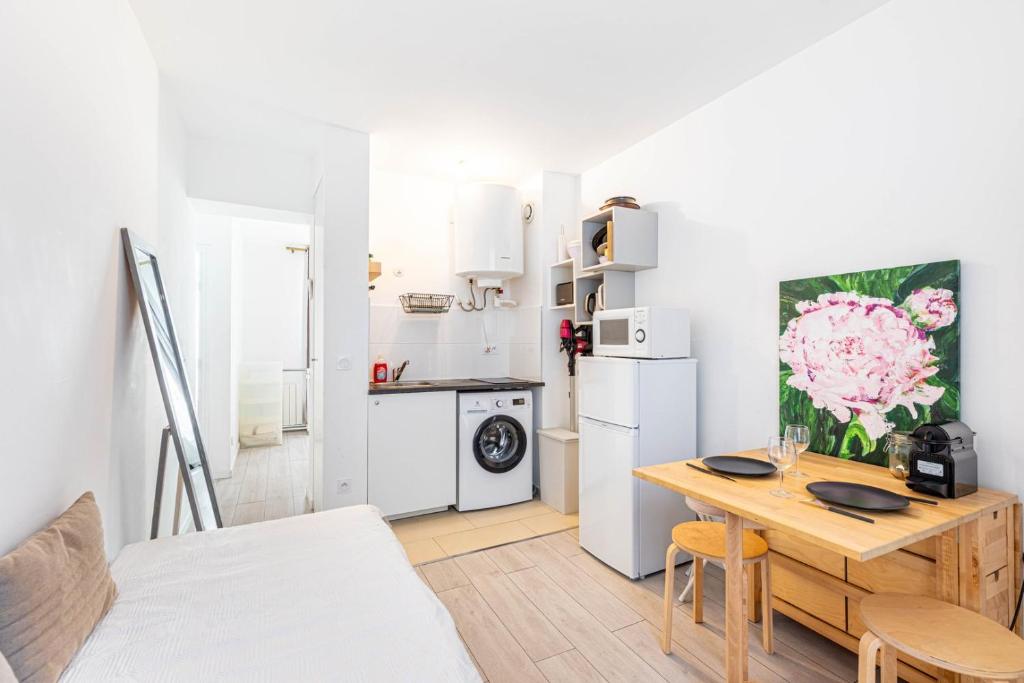 une cuisine et une salle à manger avec une table et une cuisine avec un réfrigérateur dans l'établissement GuestReady - Serene base two steps from Paris, à Boulogne-Billancourt