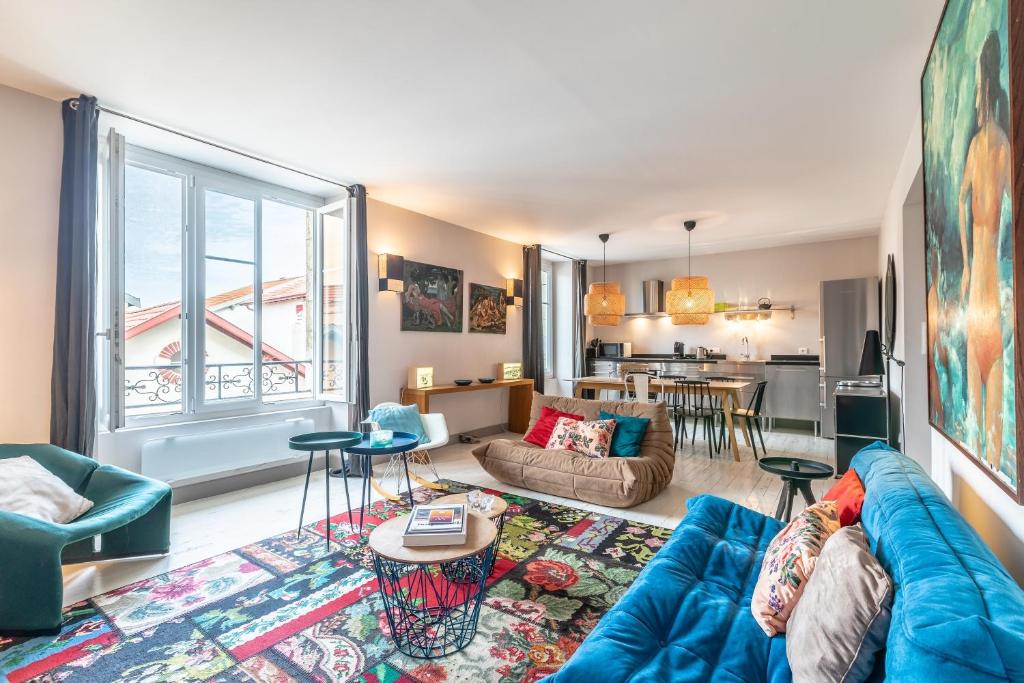 un salon avec un canapé bleu et une cuisine dans l'établissement Romy - En centre-ville, à Biarritz