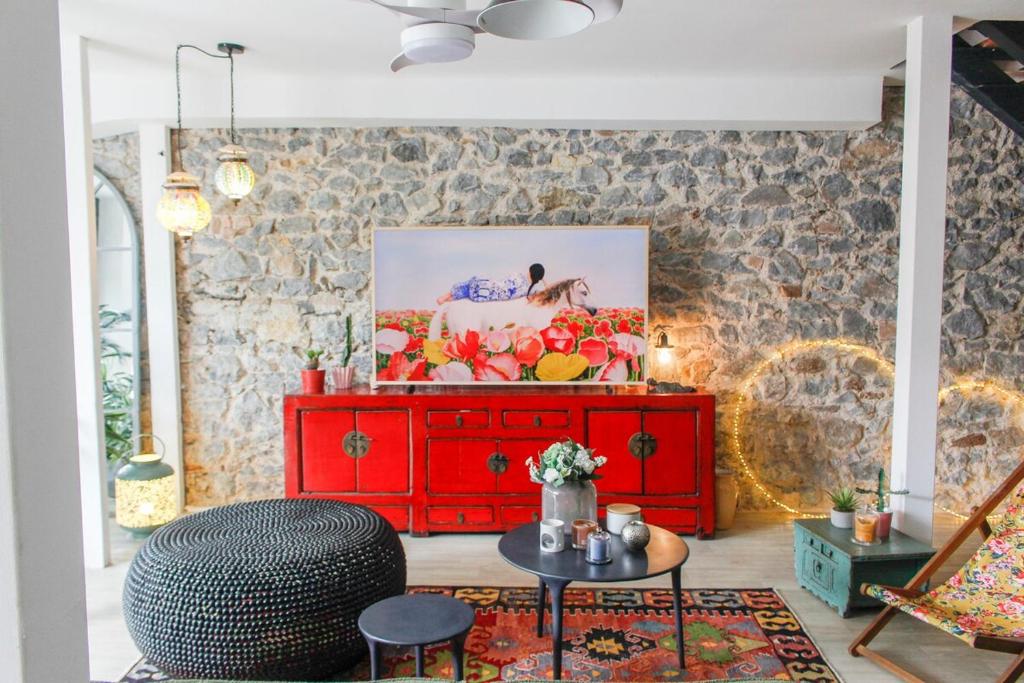 a red dresser in a room with a brick wall at Magnifique maison coloniale in Noumea