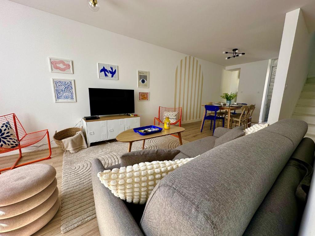 un salon avec un canapé et une télévision dans l'établissement La Pépinière - 7 Personnes - Gare - Centre Ville, au Mans