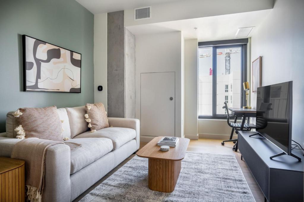 un soggiorno con un divano e una TV di Blueground SoMa pool nr Civic Center SFO-1373 a San Francisco