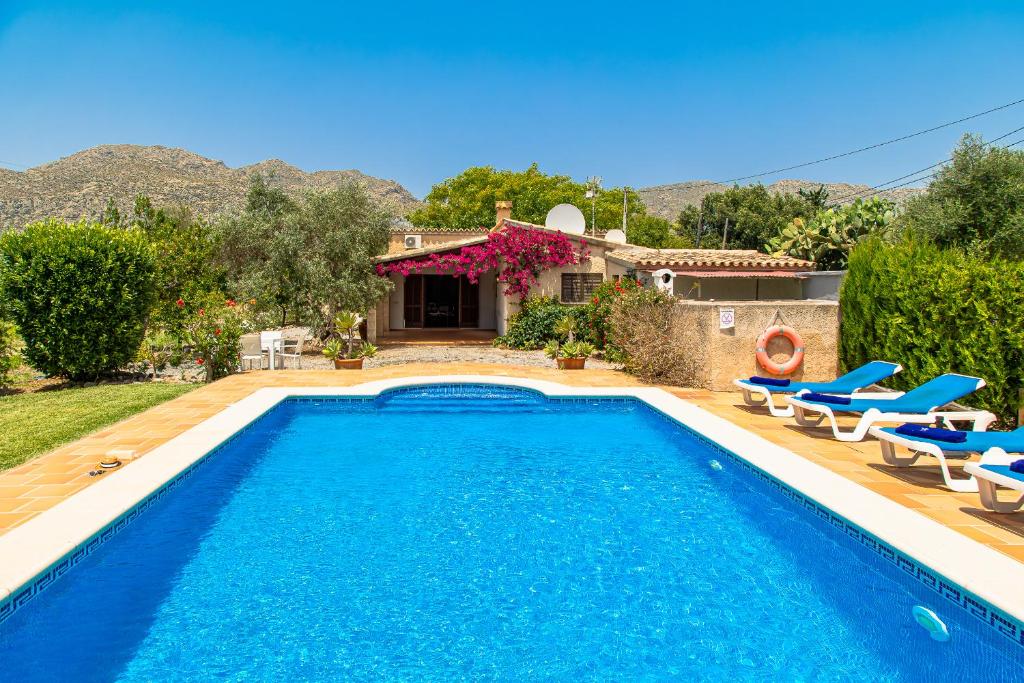 a villa with a swimming pool in front of a house at Villa Ca Na Magdalena By homevillas360 in Pollença